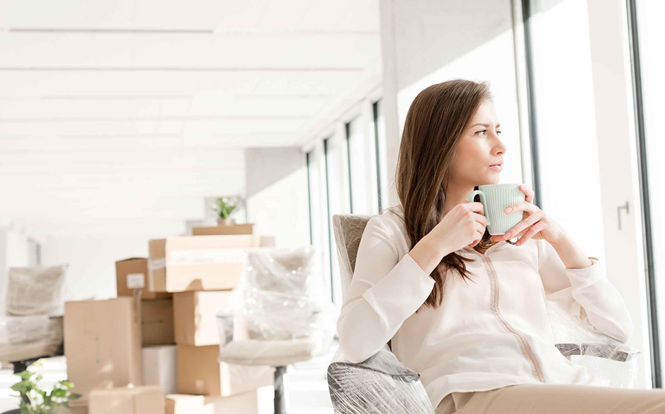 Woman with a cup of tea staring out the window