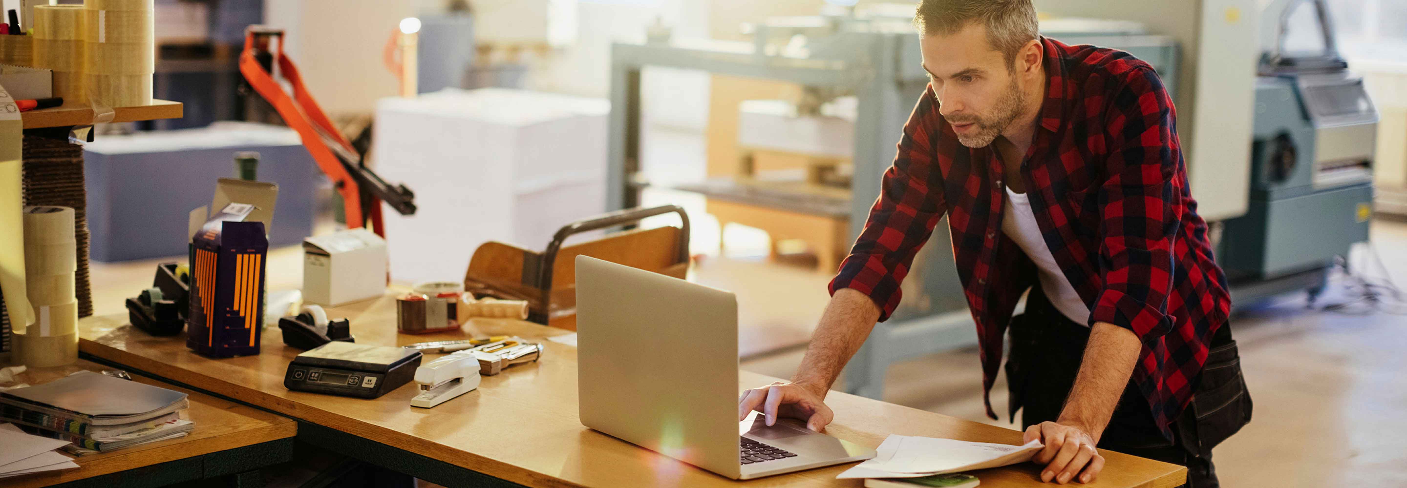 Man on laptop in construction area