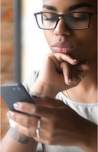 Woman looking at her phone to contact An Post Money for help