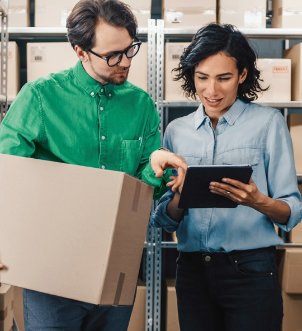 Man holding parcel looking at womans phone