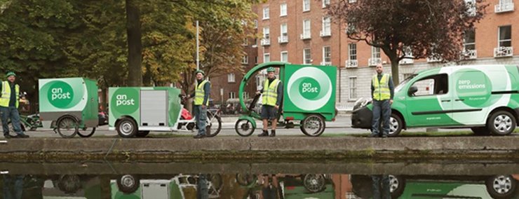 Variety of An Post zero emission vehicles and staff along the canal.