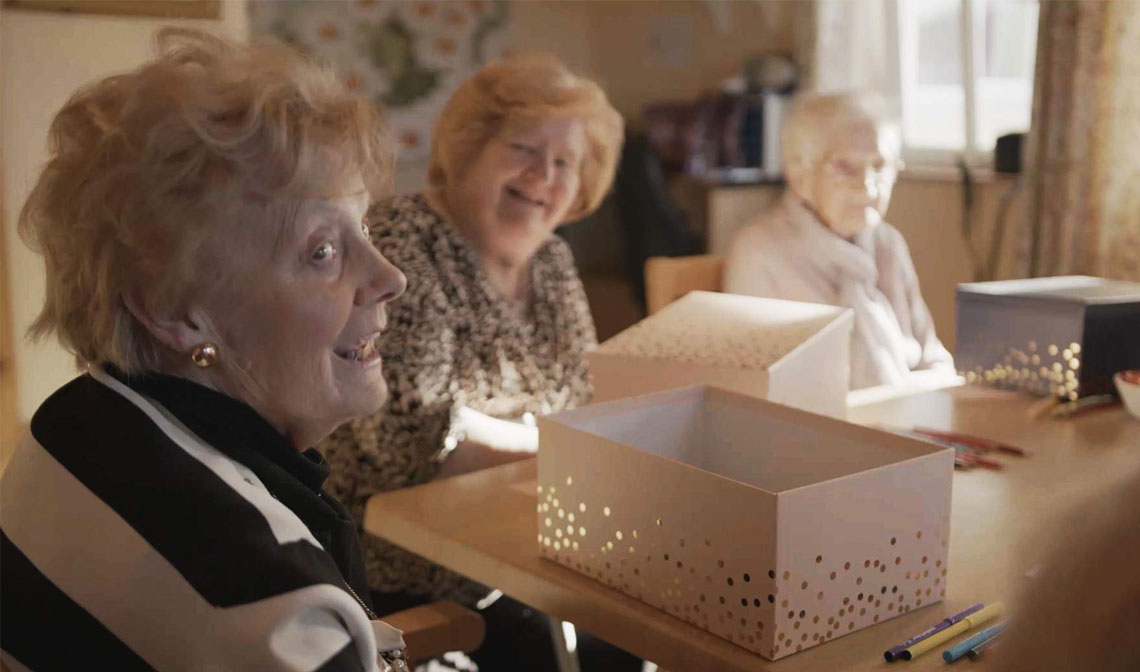 Care home residents opening a parcel