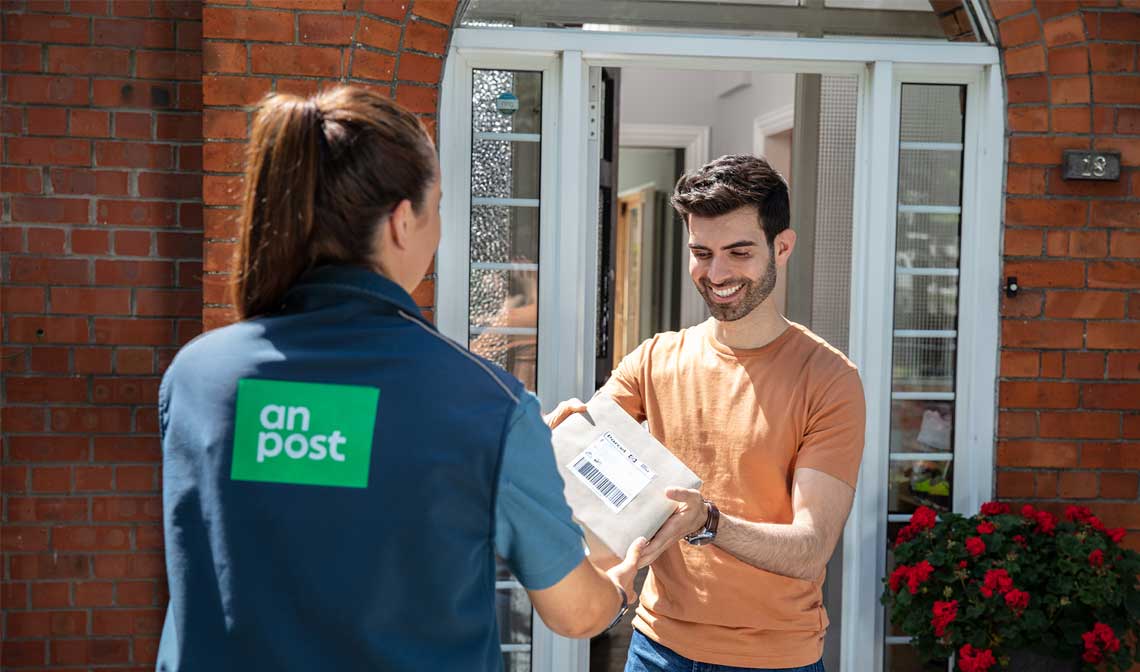  An Post postwoman delivery a package to a happy customer