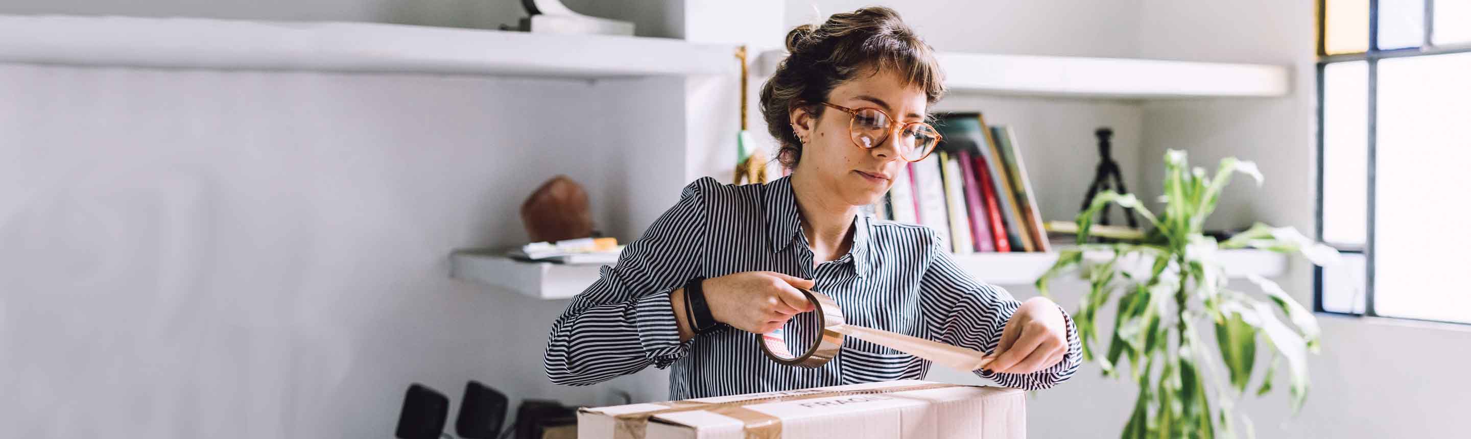 Woman sealing a package for posting