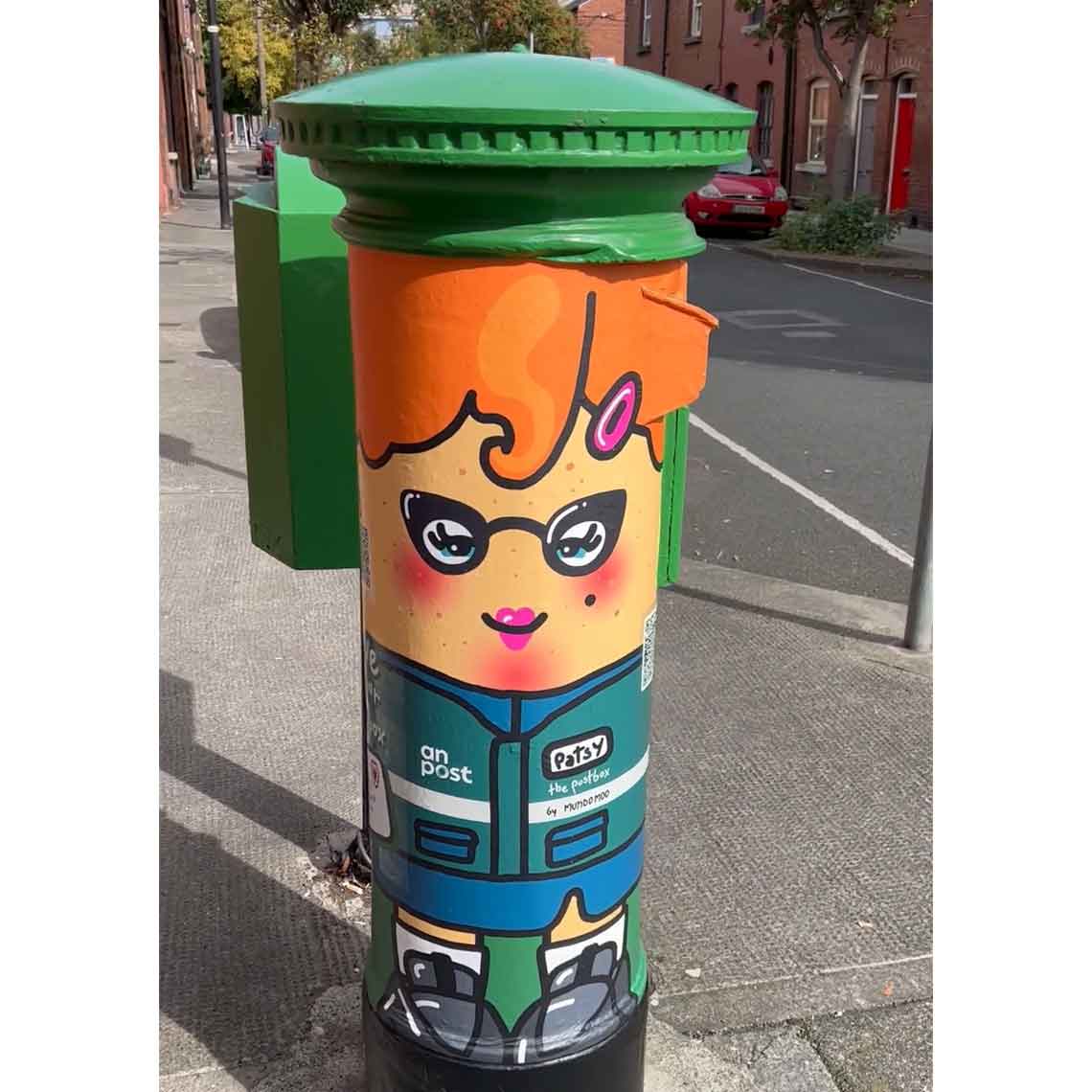 An Post pillarbox which showcases the illustrated artwork of Patsy the Postbox