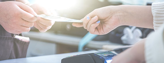 Two hands handing over cash from one to another