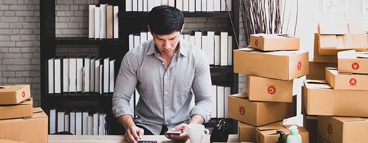 Man on his phone surrounded by parcels