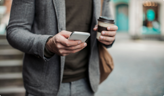 Man in grey suit with satchel looking at his phone