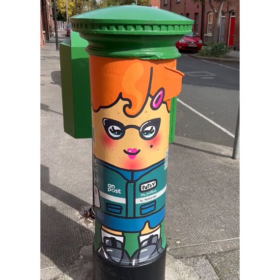 An Post pillarbox which showcases the illustrated artwork of Patsy the Postbox