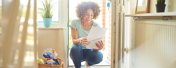 Woman at from door reading a letter