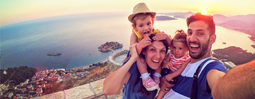 two children and a man and woman take a selfie on holidays