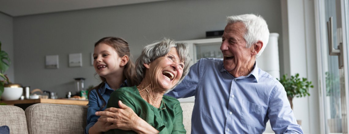 Older couple laughing with a child