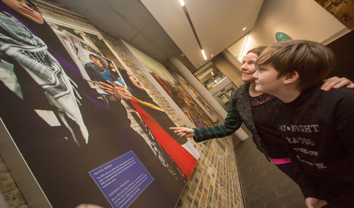 Children learning about historical events on a wall mounted panel