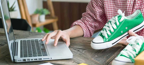 A business owner uploading green shoes to sell to their eCommerce store